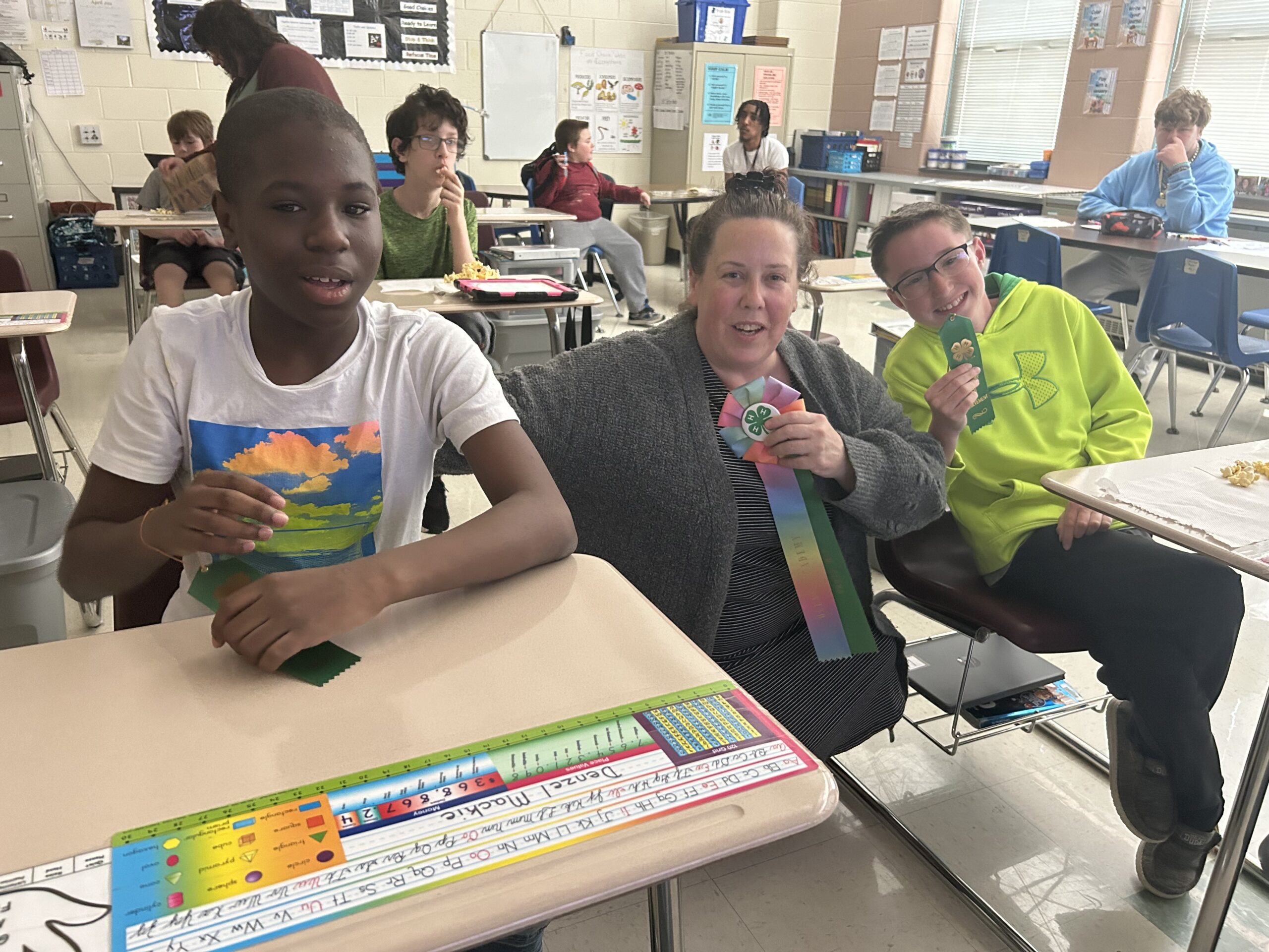 Two students and teacher holding ribbons at Special Services 4-H Club